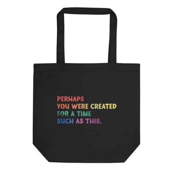 Black canvas tote bag with the Esther 4:14 quote: Perhaps you were created for a time such as this. Writing is in pride colors with an ombre faded pattern.